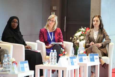 Kornelia Kiss z Culture Action Europe oraz Edyta Ruta z Instytutu Kultury Miejskiej – Miasta Splotów podczas panelu dyskusyjnego. Obie kobiety siedzą na białych fotelach, mają przed sobą notatki; w tle widać kwiaty i nowoczesne wnętrze sali konferencyjnej.